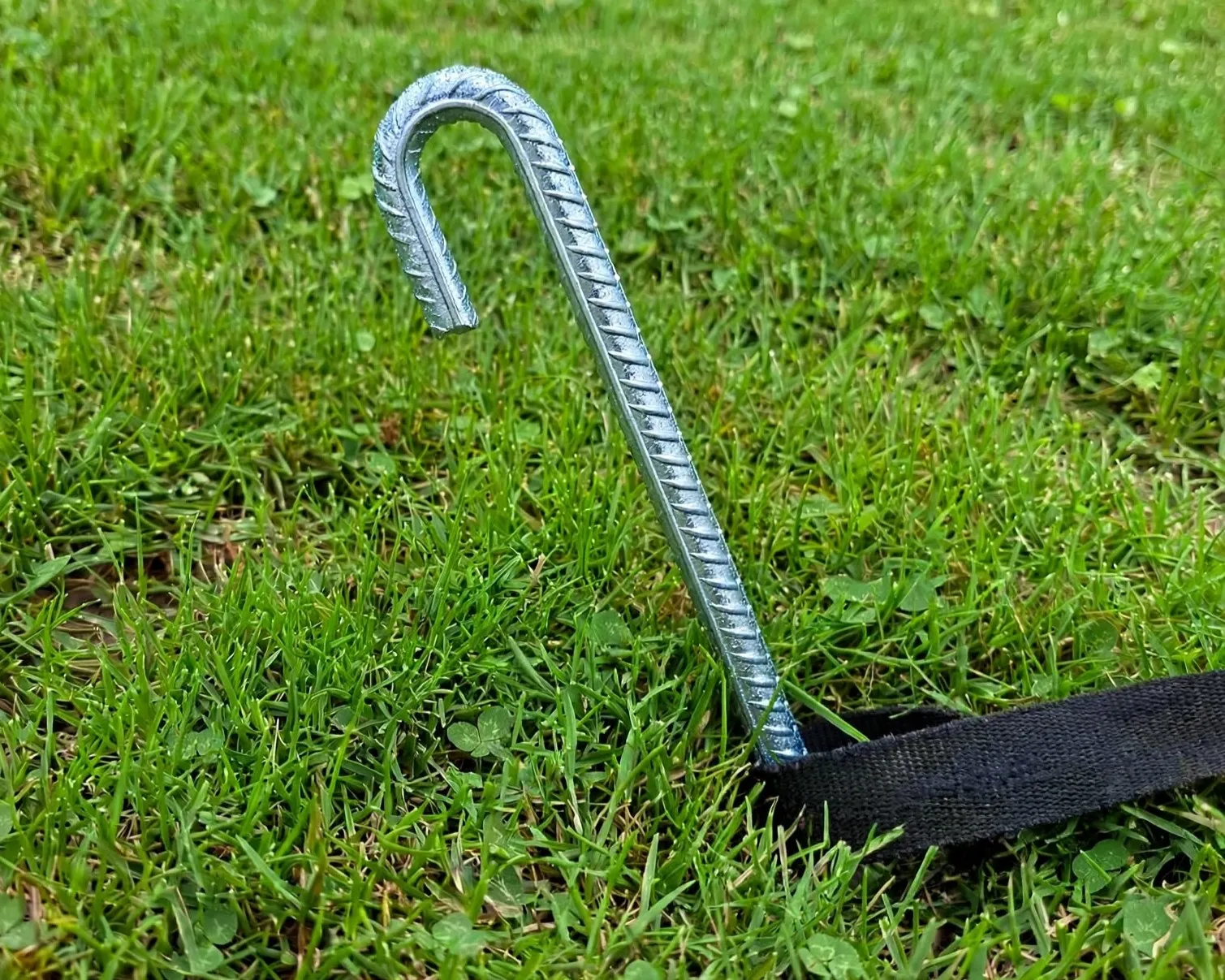 Piquet d'ancrage jeu gonflable enfoncé dans l'herbe, fixation sécurité structure gonflable conforme norme EN 14960